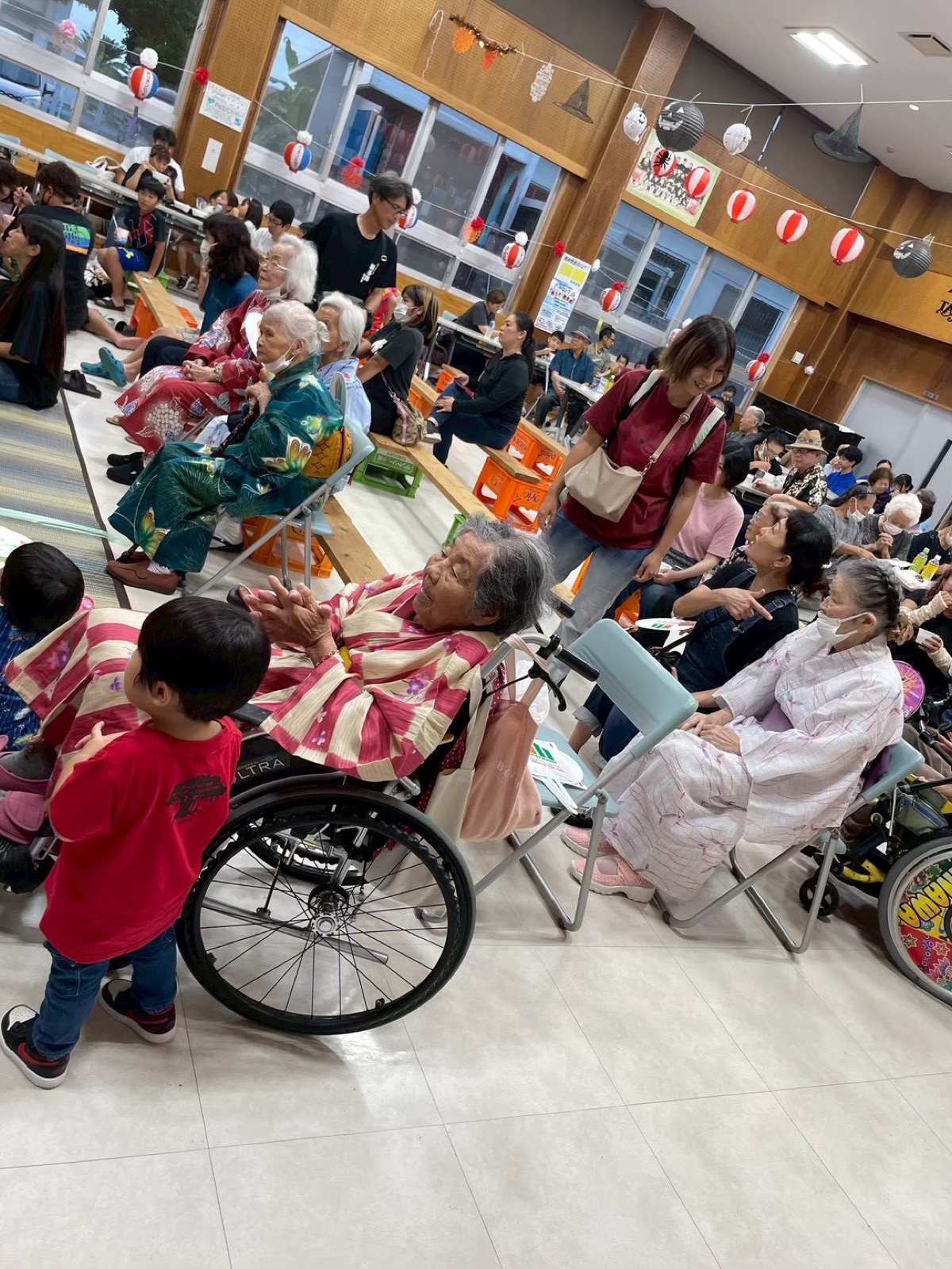 ホールに集まった利用者とスタッフ、子どもたち